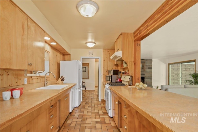 424 N Mobley Dr, Boise, ID 83712 - kitchen with white appliances, a sink, light countertops, brick patterned flooring, and a large fireplace