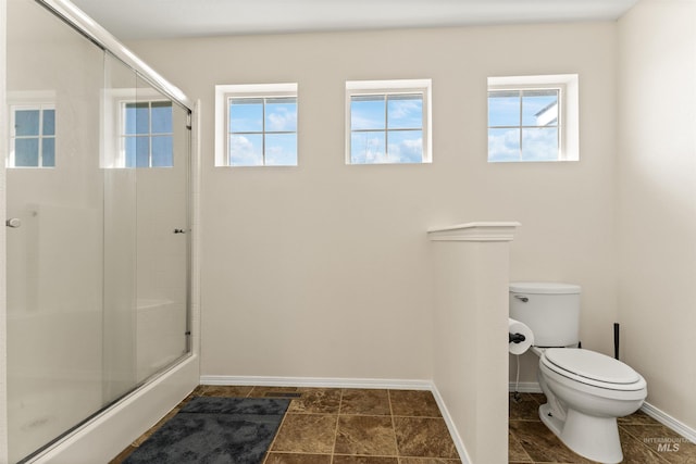 full bathroom with an enclosed shower, toilet, and baseboards