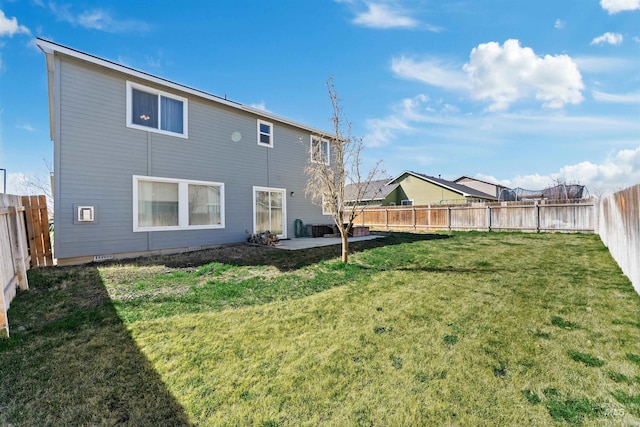 rear view of property with a yard, a fenced backyard, and a patio