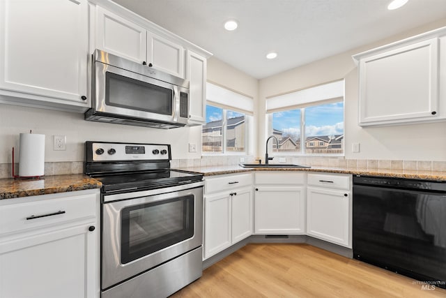 kitchen featuring white cabinetry, recessed lighting, stone countertops, appliances with stainless steel finishes, and a sink