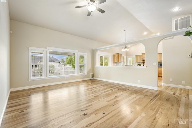 unfurnished living room featuring baseboards, visible vents, ceiling fan with notable chandelier, and light wood-type flooring