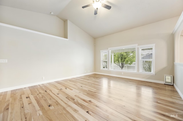 empty room featuring ceiling fan, baseboards, lofted ceiling, and light wood-type flooring
