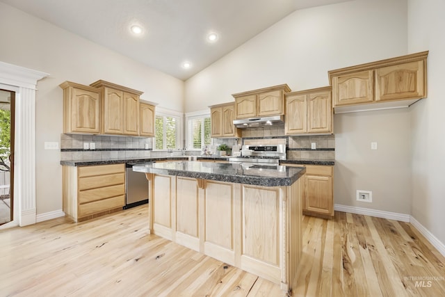kitchen with light brown cabinetry, stove, a center island, under cabinet range hood, and dishwasher