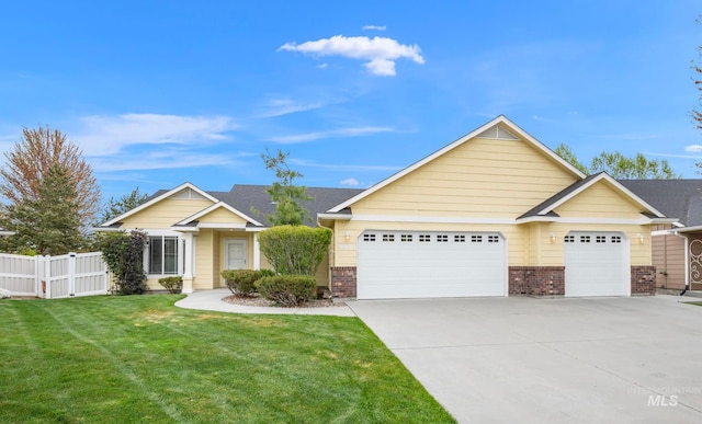 view of front of property with a front lawn, fence, brick siding, an attached garage, and driveway