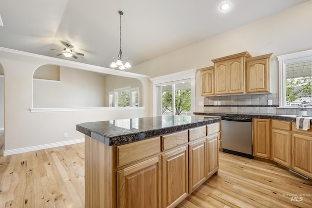 kitchen with stainless steel dishwasher, a kitchen island, light brown cabinets, light wood-style floors, and tasteful backsplash