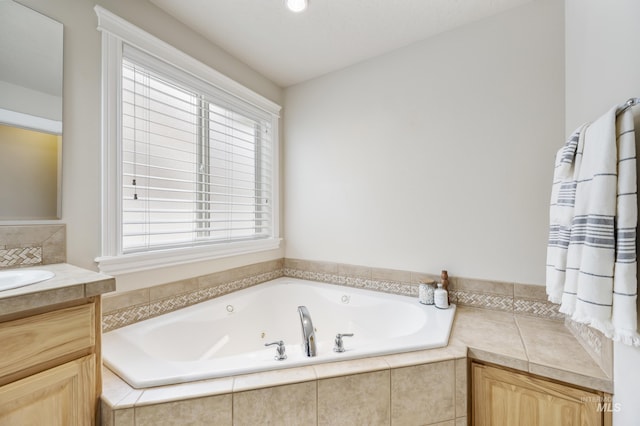 bathroom with vanity and a tub with jets