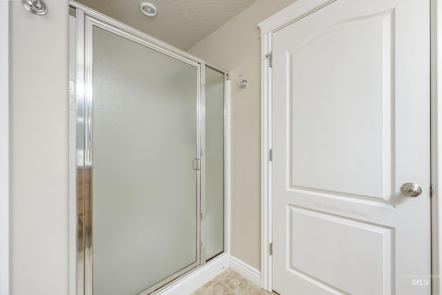 full bath featuring tile patterned floors and a stall shower