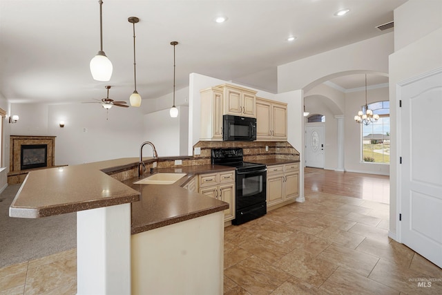 1041 Lupine Ln, Kimberly, ID 83341 - kitchen with black appliances, cream cabinetry, dark countertops, arched walkways, and backsplash