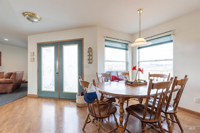 dining space featuring light wood-type flooring and french doors