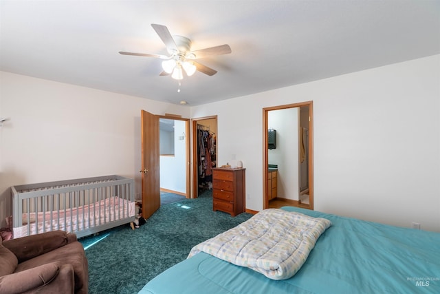 bedroom featuring dark carpet, a spacious closet, a closet, and ceiling fan