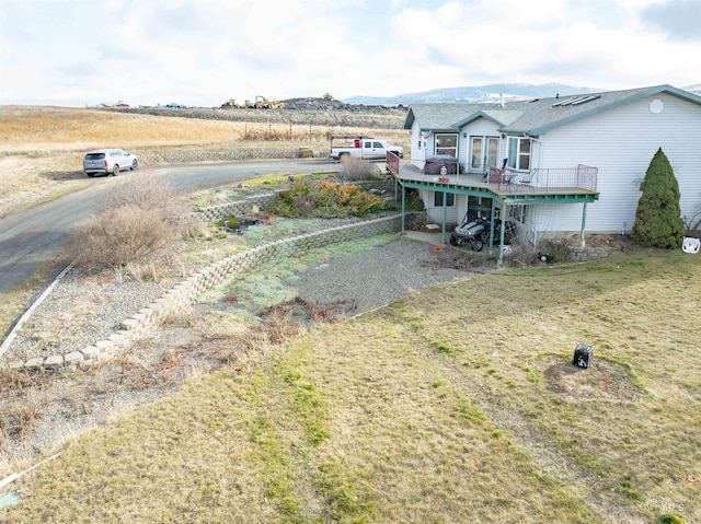 view of yard with a deck with mountain view