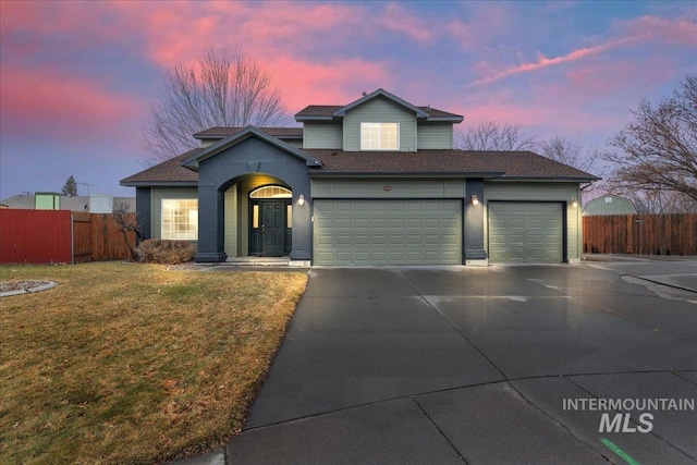 view of front property featuring a garage and a yard