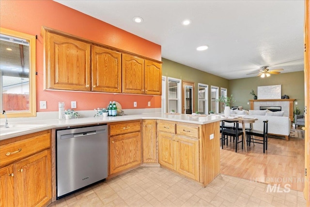 kitchen featuring dishwasher, sink, ceiling fan, and kitchen peninsula