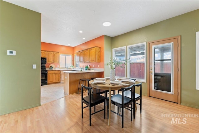 dining area featuring light hardwood / wood-style flooring and a textured ceiling