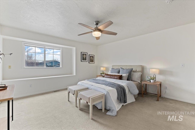 carpeted bedroom with ceiling fan and a textured ceiling