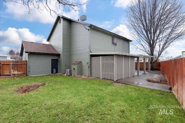 rear view of property with cooling unit, a yard, and a patio area