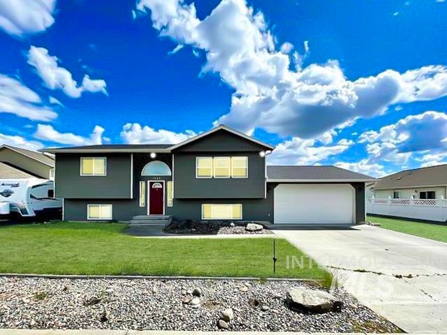 bi-level home with a garage and a front yard