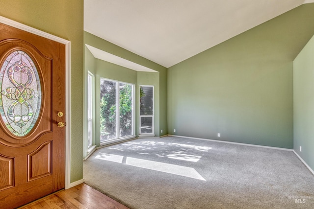 entrance foyer with hardwood / wood-style floors and vaulted ceiling