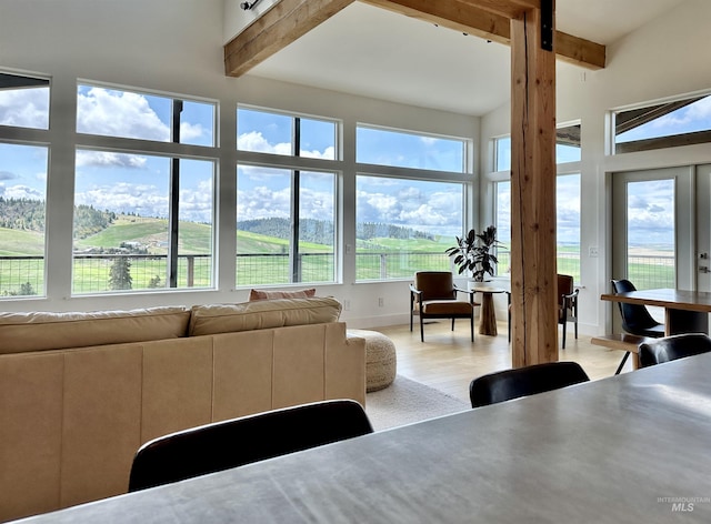 living area featuring light wood-type flooring and beamed ceiling