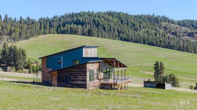 exterior space featuring a front yard, a forest view, and a mountain view