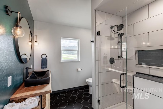 full bathroom with tile patterned flooring, a shower stall, toilet, vanity, and baseboards
