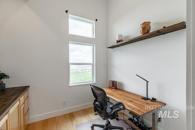 office with light wood finished floors, baseboards, and plenty of natural light