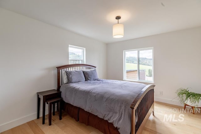 bedroom featuring baseboards and light wood-style floors