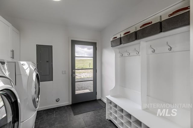 laundry area with washing machine and dryer, electric panel, baseboards, dark tile patterned flooring, and laundry area