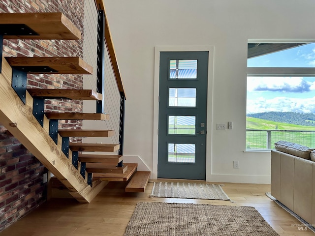 foyer entrance with baseboards, hardwood / wood-style flooring, and stairs