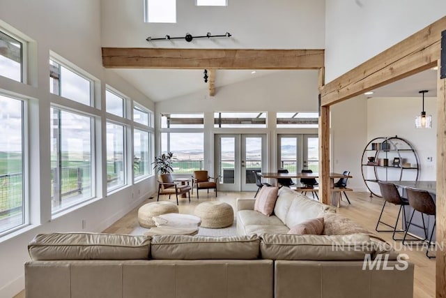 living room with beam ceiling, light wood-style flooring, and high vaulted ceiling