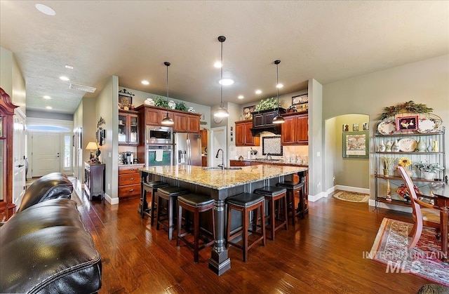 10318 W Adirondack Ct, Star, ID 83669 - kitchen featuring appliances with stainless steel finishes, a sink, a breakfast bar, baseboards, and dark wood finished floors