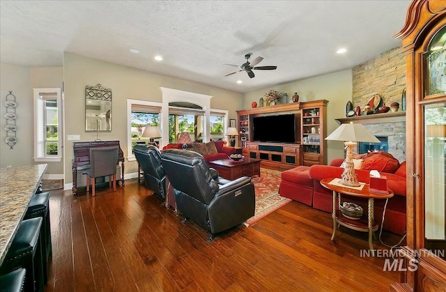 10318 W Adirondack Ct, Star, ID 83669 - living room featuring ceiling fan, dark wood-style flooring, recessed lighting, a fireplace, and a textured ceiling