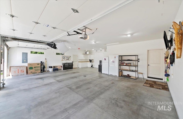 10318 W Adirondack Ct, Star, ID 83669 - garage with a garage door opener, electric panel, and freestanding refrigerator