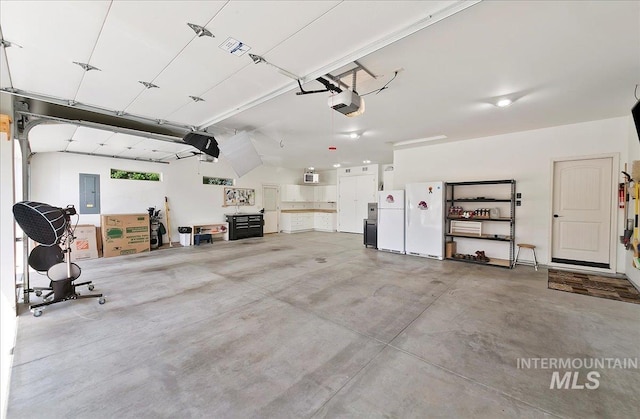 10318 W Adirondack Ct, Star, ID 83669 - garage featuring freestanding refrigerator, a garage door opener, and electric panel