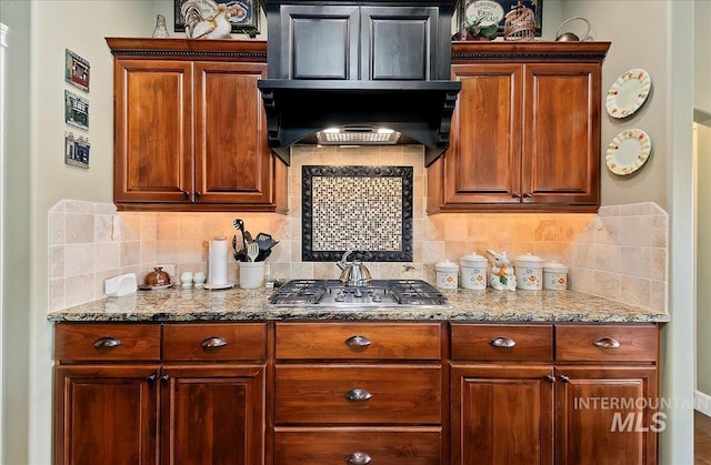 10318 W Adirondack Ct, Star, ID 83669 - kitchen with stainless steel gas cooktop, light stone countertops, decorative backsplash, and brown cabinets