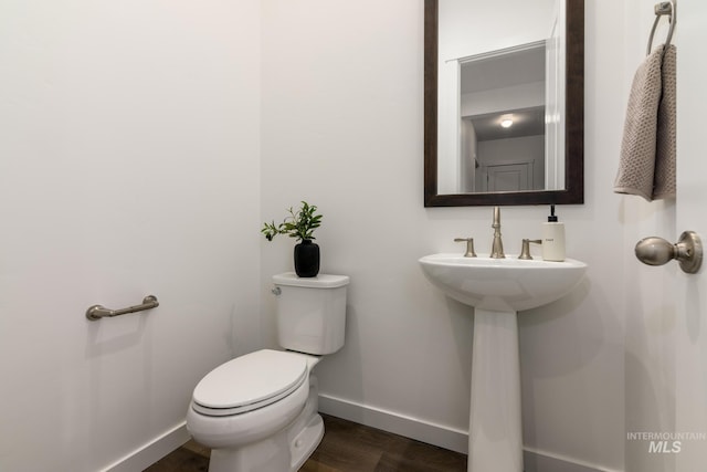 bathroom featuring wood finished floors, toilet, and baseboards