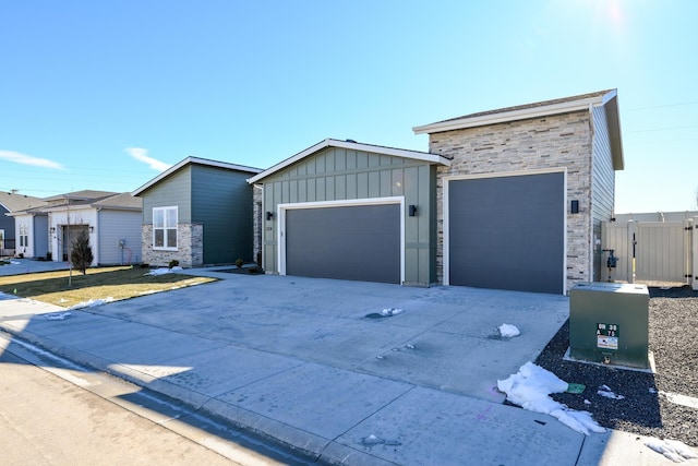 view of front of property with a garage, stone siding, board and batten siding, and concrete driveway
