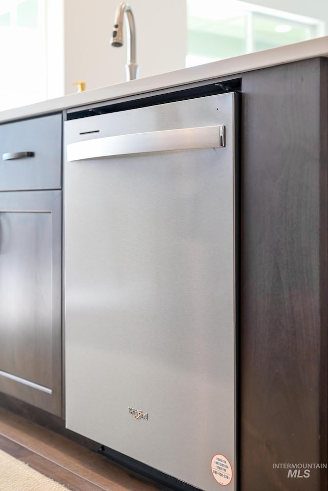 interior details featuring light countertops, dishwasher, and wood finished floors