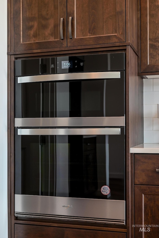 room details with double oven, decorative backsplash, dark brown cabinets, and light countertops