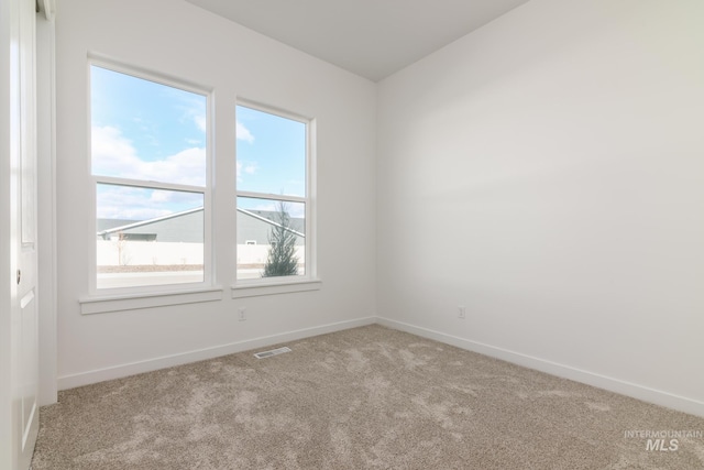 spare room with baseboards, visible vents, and carpet flooring