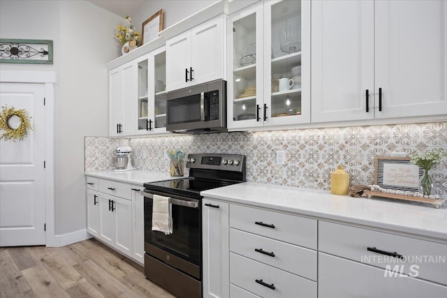 942 Paintbrush, Kimberly, ID 83341 - kitchen with appliances with stainless steel finishes, decorative backsplash, light wood-type flooring, and white cabinetry