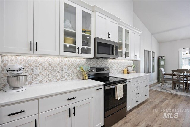 942 Paintbrush, Kimberly, ID 83341 - kitchen featuring appliances with stainless steel finishes, lofted ceiling, backsplash, light wood-style flooring, and white cabinetry