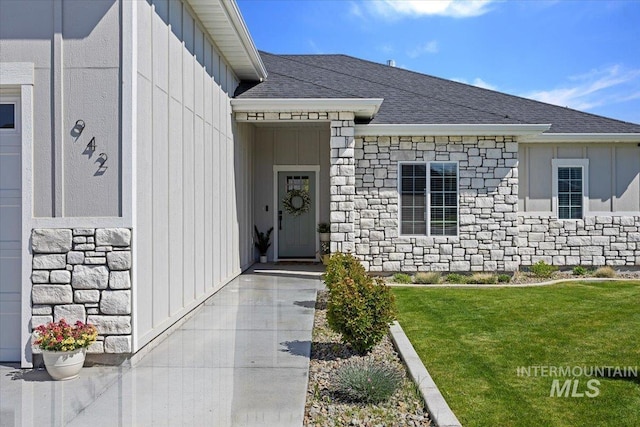 942 Paintbrush, Kimberly, ID 83341 - view of exterior entry featuring stone siding, board and batten siding, roof with shingles, and a lawn