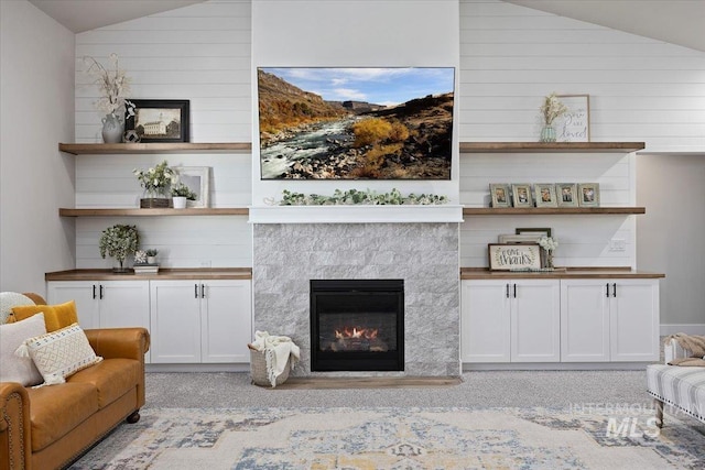 942 Paintbrush, Kimberly, ID 83341 - living room with lofted ceiling, a glass covered fireplace, wooden walls, and light carpet