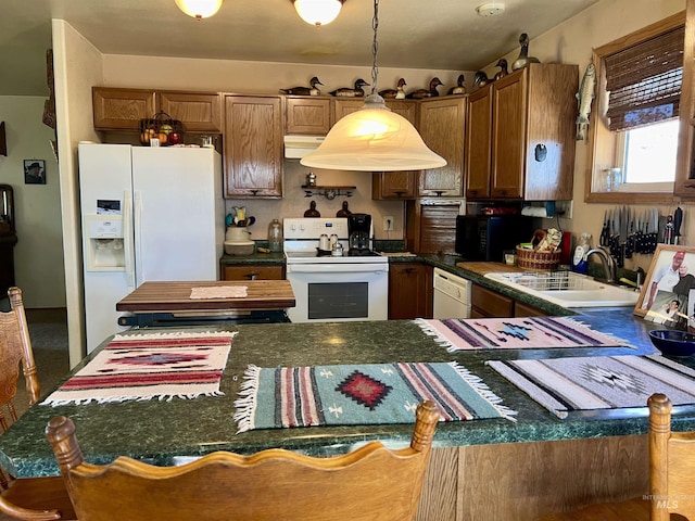 kitchen with sink, white appliances, and pendant lighting