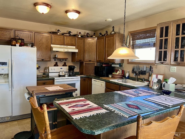 kitchen featuring white appliances, sink, hanging light fixtures, kitchen peninsula, and a breakfast bar area