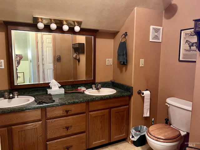 bathroom featuring vanity, toilet, and a textured ceiling