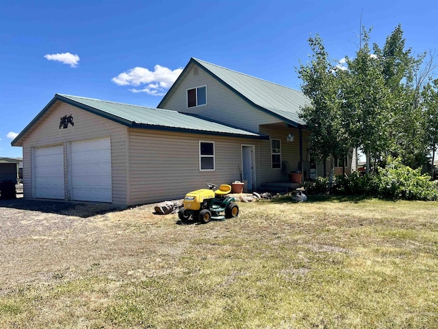 exterior space with a garage and a lawn