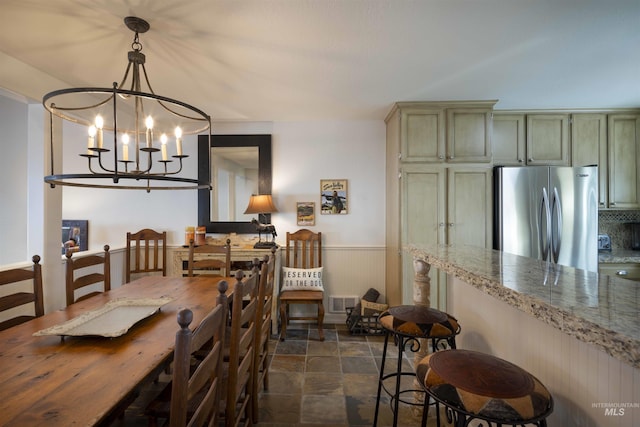 2639 Ridge Ln, Sun Valley, ID 83353 - dining space featuring a chandelier, dark stone finish flooring, and a wainscoted wall