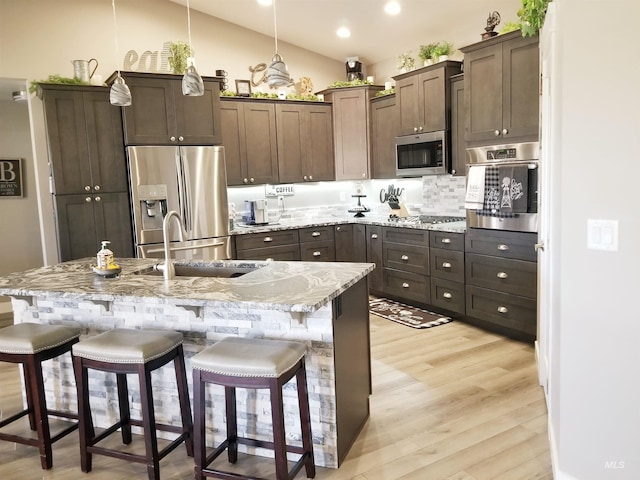 3847 N 2456 E, Filer, ID 83328 - kitchen with light wood finished floors, appliances with stainless steel finishes, light stone counters, a breakfast bar area, and vaulted ceiling